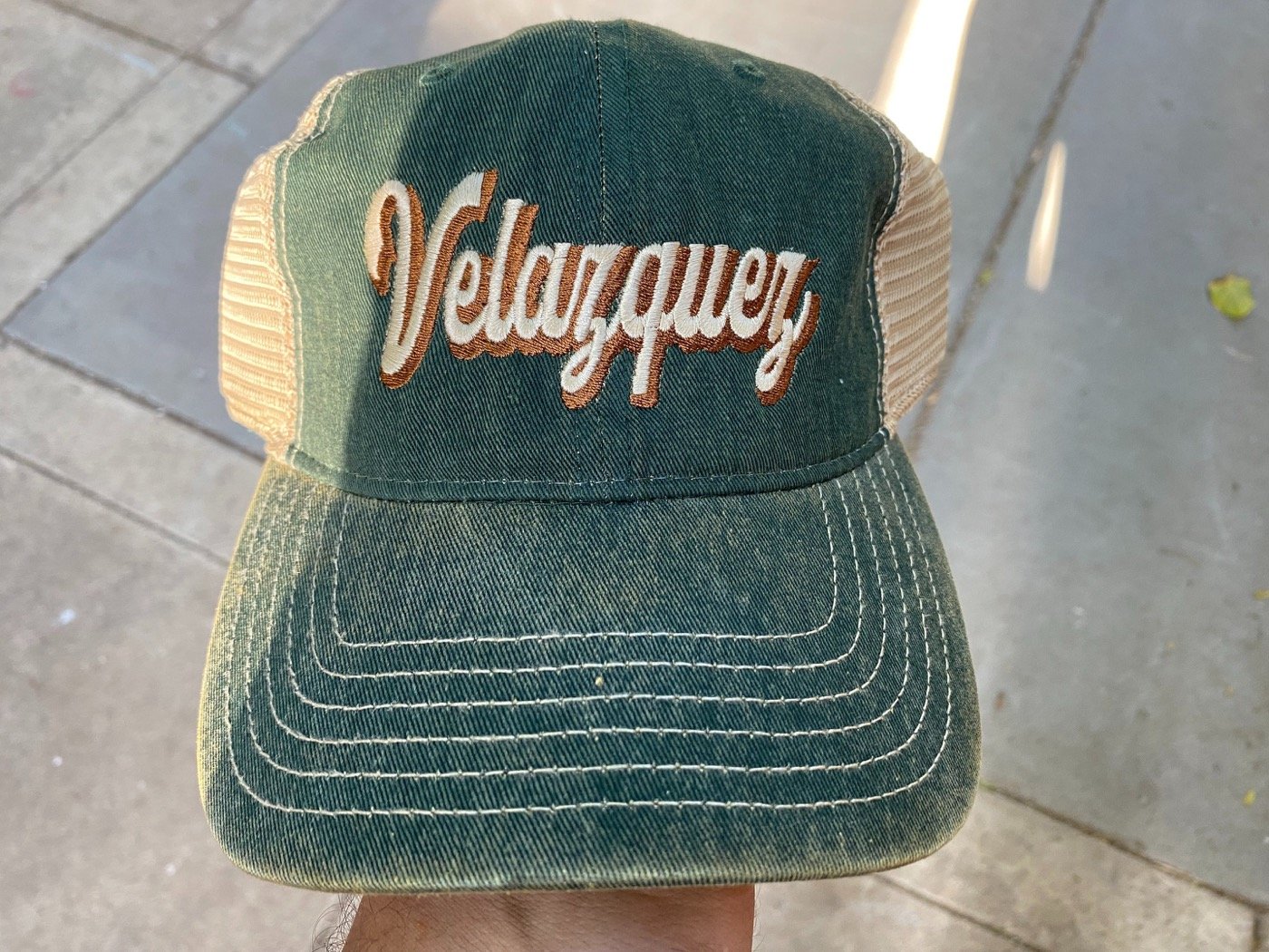 Embroidered green trucker hat reading Velazquez